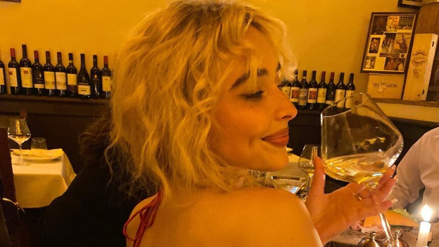 sabrina carpenter goes bra free in a backless ruby red dress while sipping wine 68757c1099706